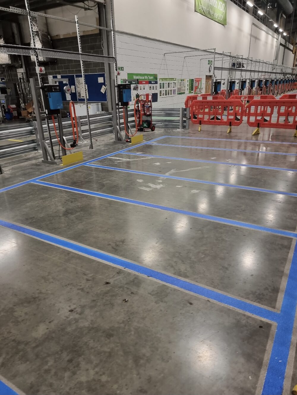 UV-cured blue bay markings on a polished warehouse floor