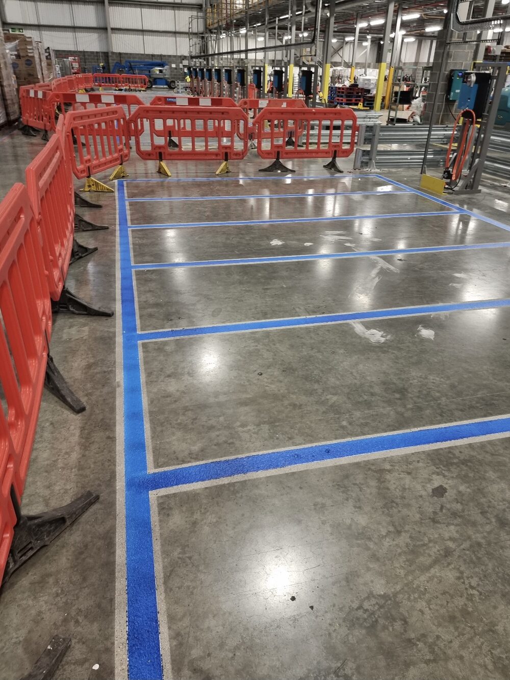 UV-cured charging-lane markings running the length of the warehouse